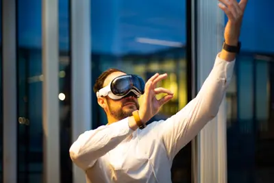 En man med VR-glasögon och vit skjorta gestikulerar framför ett fönster.