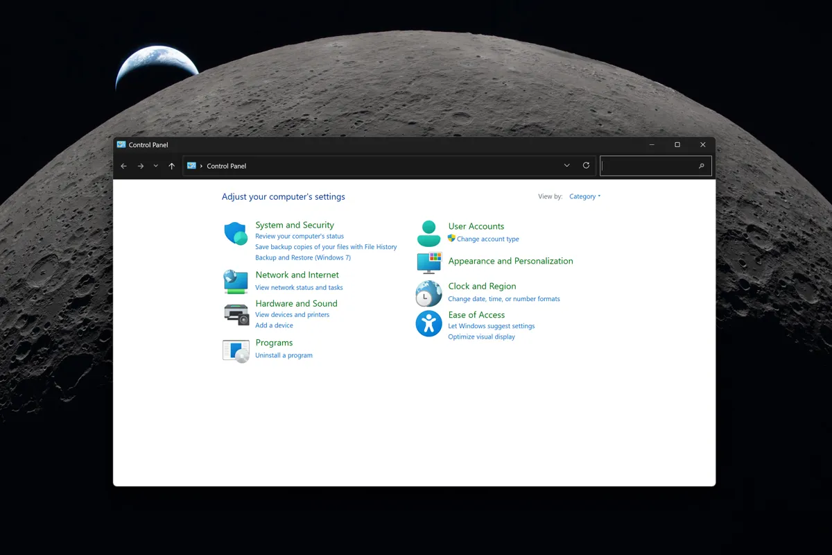 En skärmdump av Windows Kontrollpanel visas mot en bakgrund av månen. Kontrollpanelen visar olika inställningskategorier.
