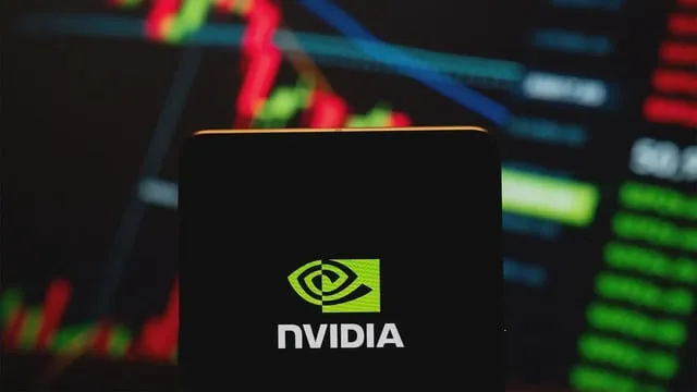 En mobiltelefon visar Nvidias logga mot en bakgrund av aktiegrafer.