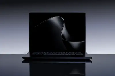 En svart Surface Laptop Ultra står på ett blankt underlag med en abstrakt svart bakgrundsbild.