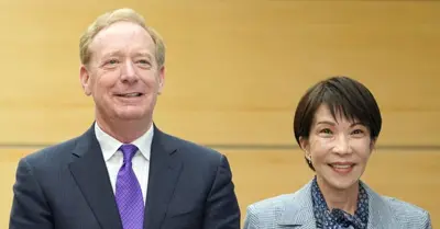 Två personer, en man i kostym och en kvinna i kavaj, står bredvid varandra och ler mot kameran.