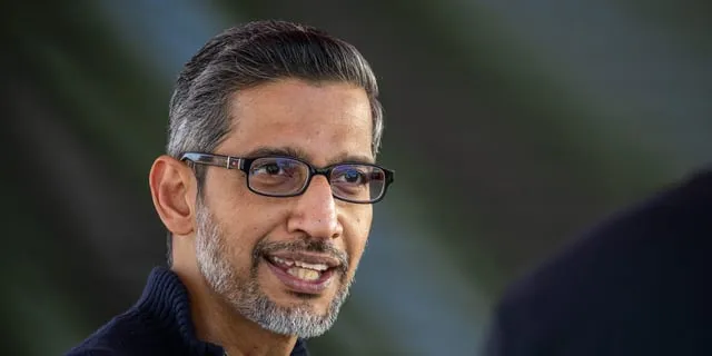 Närbild på Sundar Pichai, vd för Google, med glasögon och gråsprängt skägg. Han talar.